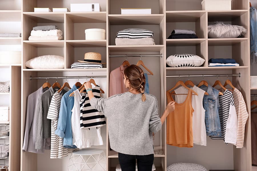 DIY Wardrobe planner - Woman choosing outfit from large wardrobe